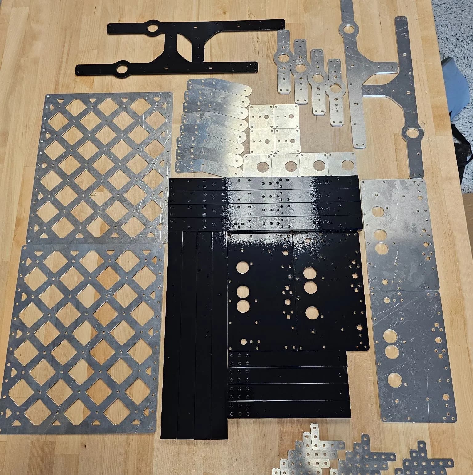 Cut parts laid out: lattice decks, anodised and bare